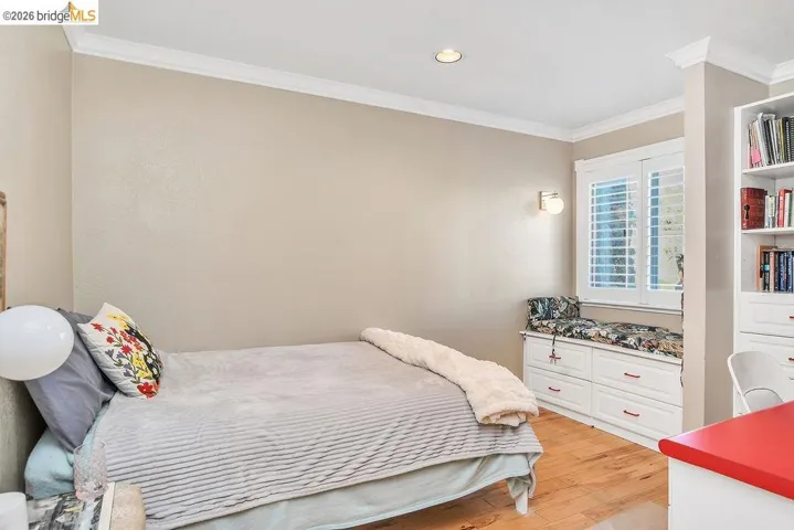Bedroom featuring ornamental molding, light wood-style flooring, and recessed lighting