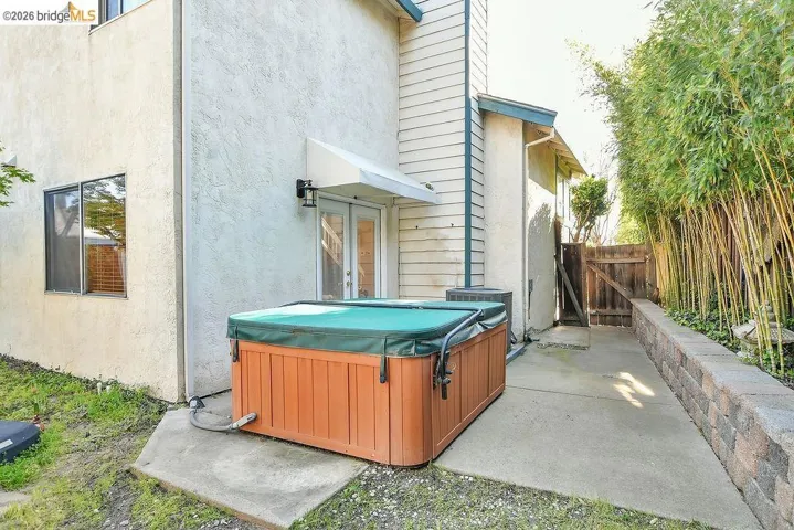 Back of property featuring a patio, a gate, and stucco siding