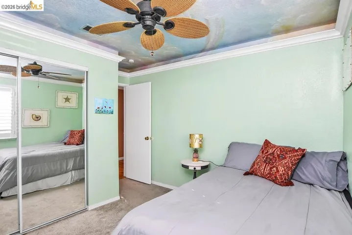 Bedroom featuring carpet flooring, a closet, a ceiling fan, and ornamental molding