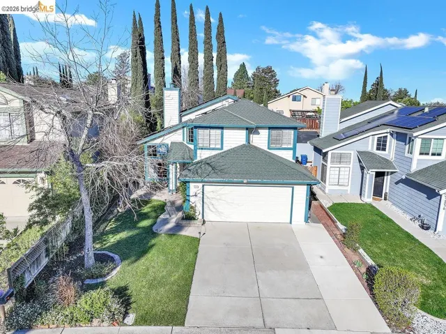 View of front of house with a front lawn, driveway, a residential view, and a garage