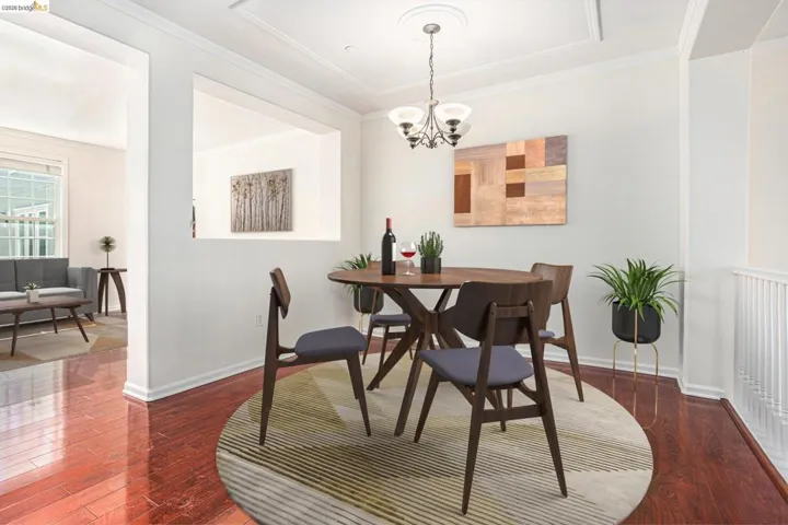 Dining area featuring dark wood-style floors, ornamental molding, and a chandelier