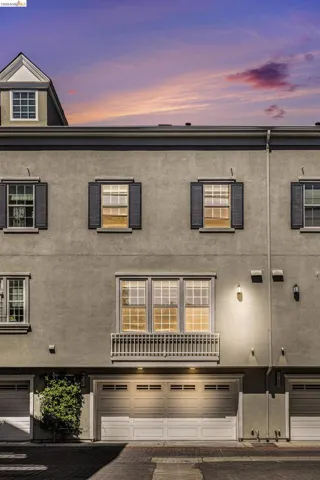 Back of property at dusk featuring a garage and stucco siding