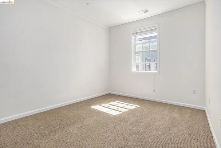 Carpeted spare room with baseboards and crown molding