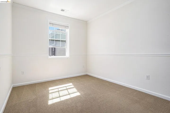 Carpeted spare room with baseboards and ornamental molding