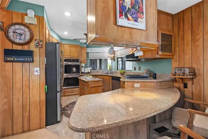 Kitchen with counter seating, stainless appliances and gas cooktop.