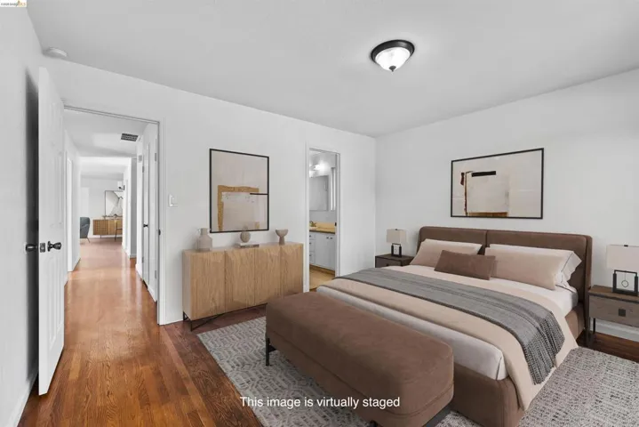 Bedroom featuring dark wood-type flooring and ensuite bath