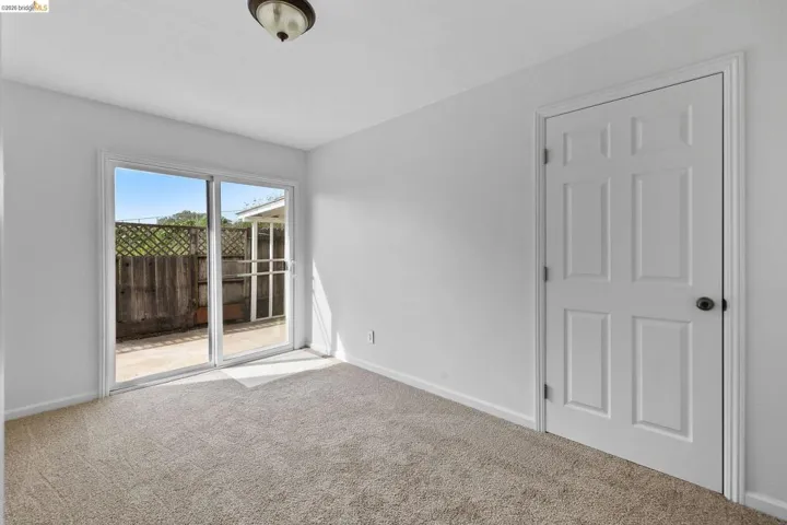 Empty room featuring light carpet and baseboards