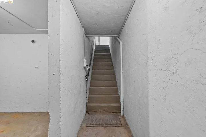 Stairs featuring unfinished concrete flooring