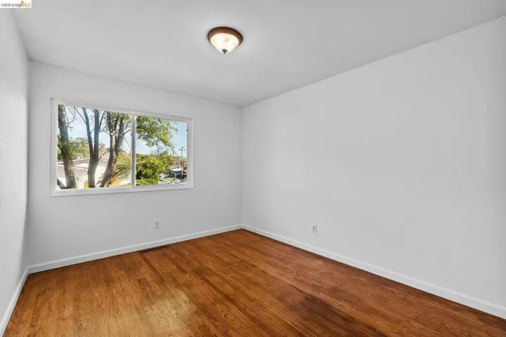 Empty room featuring baseboards and dark wood-type flooring