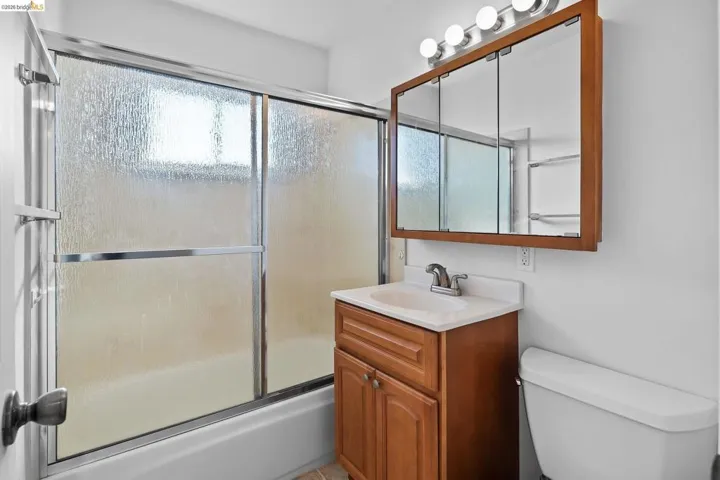 Bathroom featuring vanity and combined bath / shower with glass door