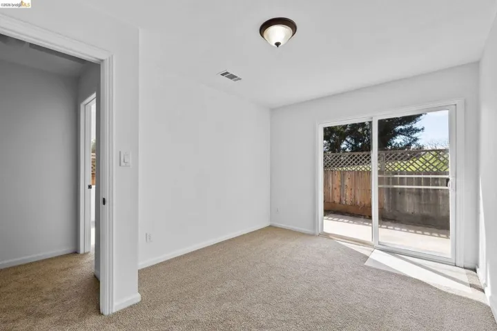 Spare room with light colored carpet and baseboards