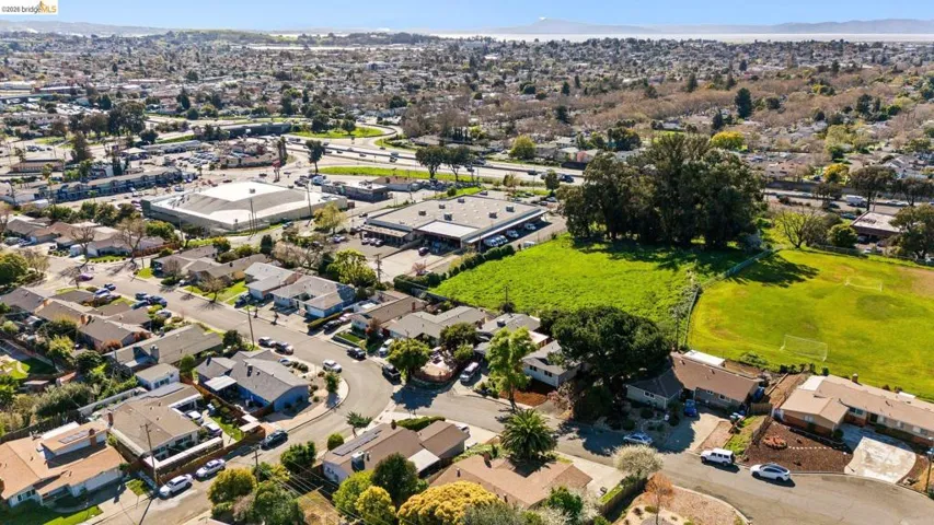 Aerial overview of property's location with a mountainous background and nearby suburban area