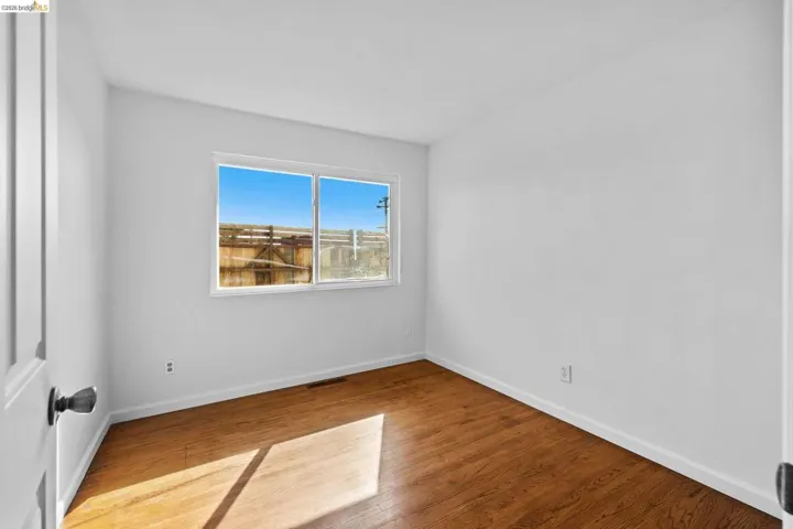 Spare room with baseboards and wood finished floors