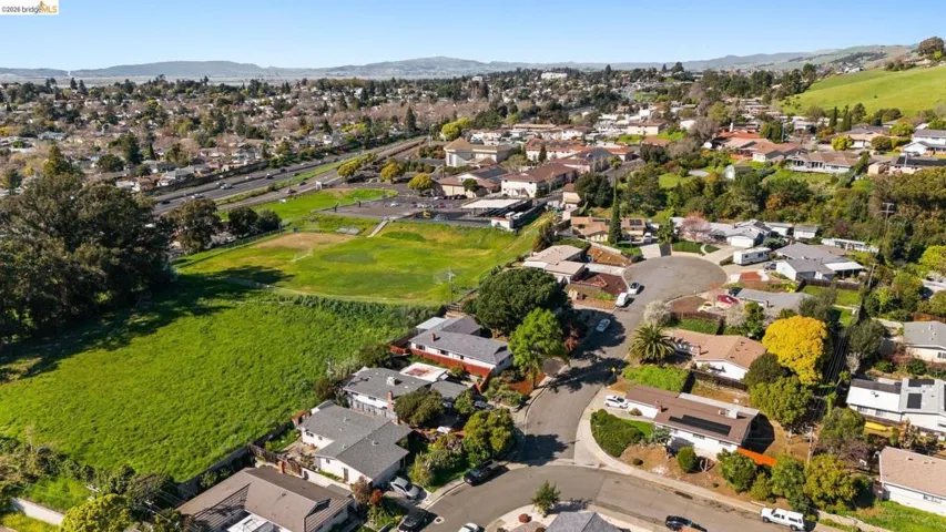 View of property location featuring a mountain backdrop, nearby suburban area, and a golf club
