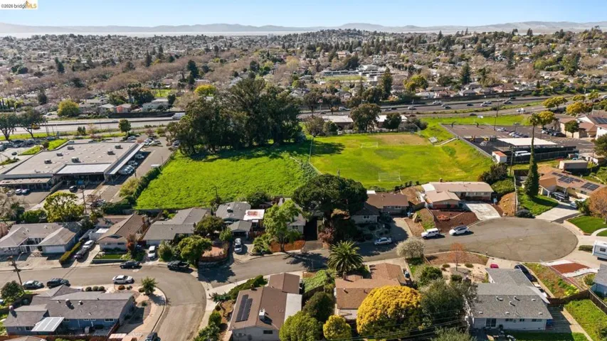 Aerial overview of property's location featuring nearby suburban area and a mountain backdrop