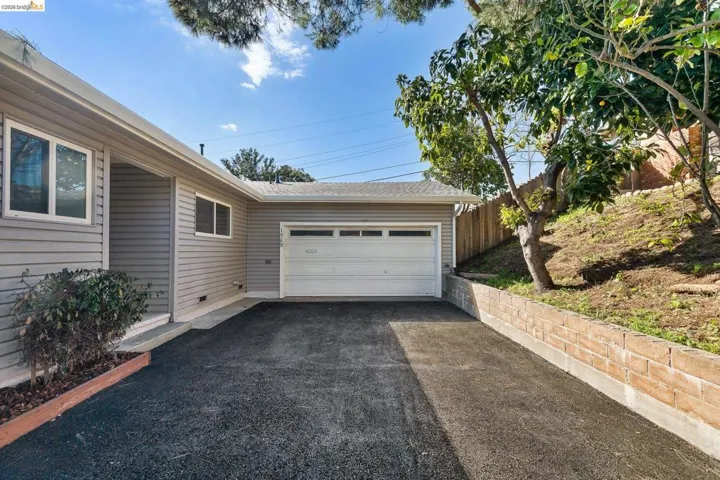Garage featuring asphalt driveway