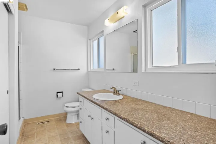 Full bathroom featuring a shower stall, vanity, and light tile patterned floors