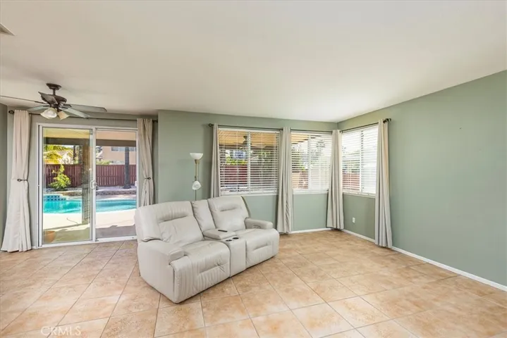 Portion of family room with views out to covered patio and sparkling pool