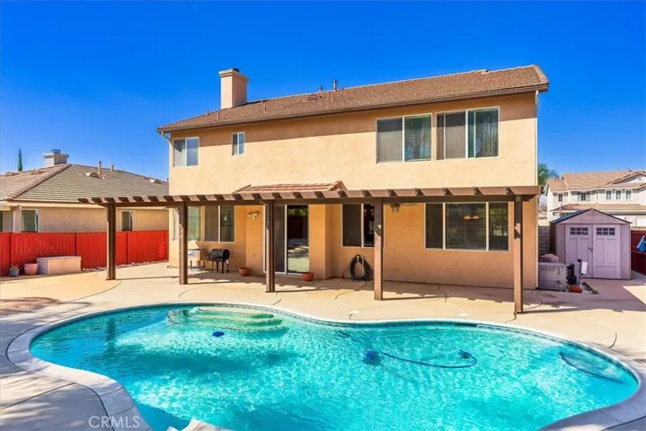 Concrete side yard with pool equipment.  Storage shed included.