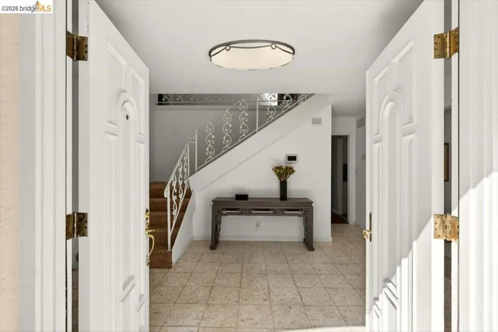 Entrance foyer featuring light floors and stairs