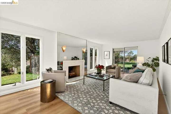 Living room featuring wood finished floors, a premium fireplace, a textured ceiling, and crown molding