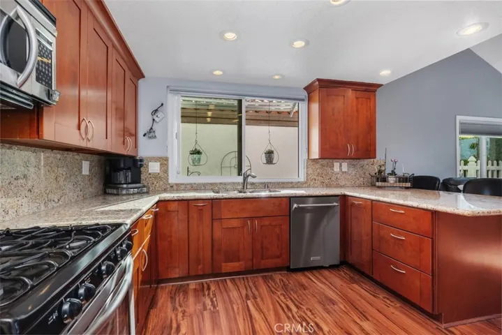 Remodeled Kitchen with Cherrywood Cabinetry and Granite Countertops and Backsplash