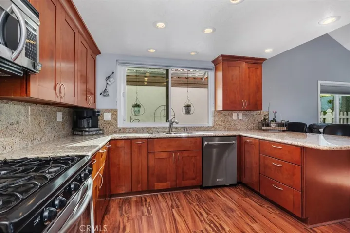 Remodeled Kitchen with Cherrywood Cabinetry and Granite Countertops and Backsplash