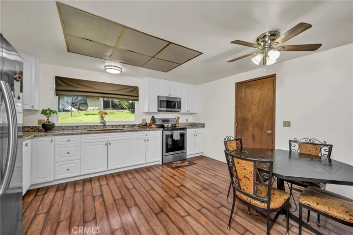 Open kitchen with stainless appliances and door to the garage.
