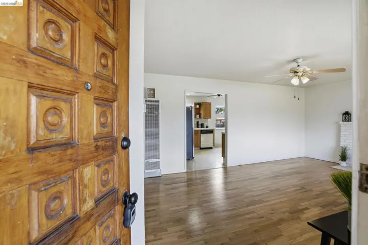 Foyer entrance with a heating unit, dark wood-style flooring, and ceiling fan