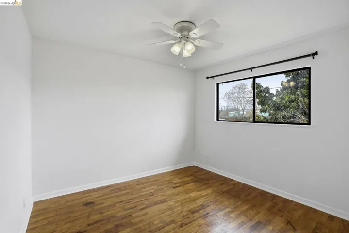 Unfurnished room featuring hardwood / wood-style floors and ceiling fan