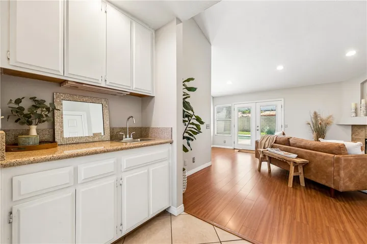 Wet-bar with floor-to-ceiling cabinetry and spacious countertops, as you enter the family room featuring French doors to the pool, and a lovely fireplace.