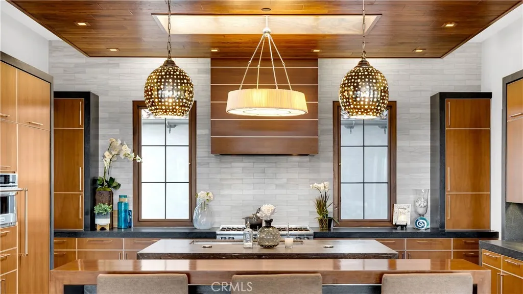 State of the art appliances include a Sub Zero double refrigerator and freezer, a Viking 8 burner range, with custom range hood, double oven and microwave . Two appliance garage units flank the back windows.Notice the exact placement of the lighting.