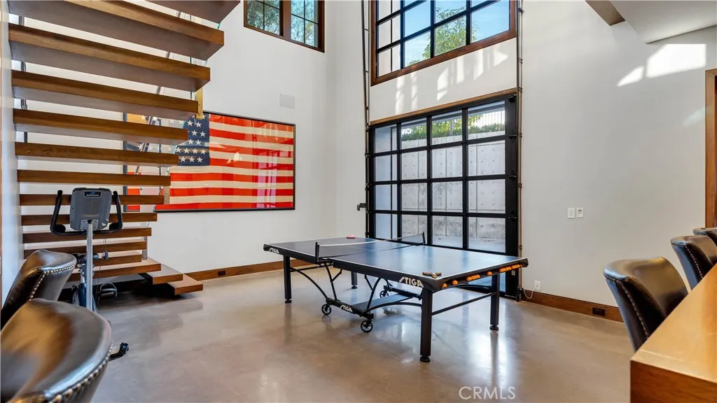 Head downstairs to one of several "flex spaces" This one combines a game room with...