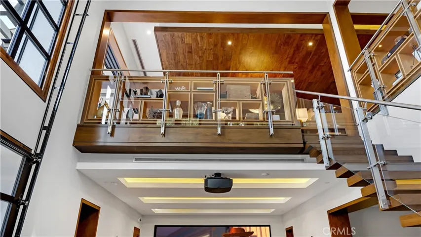 A view of the custom woodwork  upstairs while you are in the media room. The glass and metal stair railing is one of a kind.