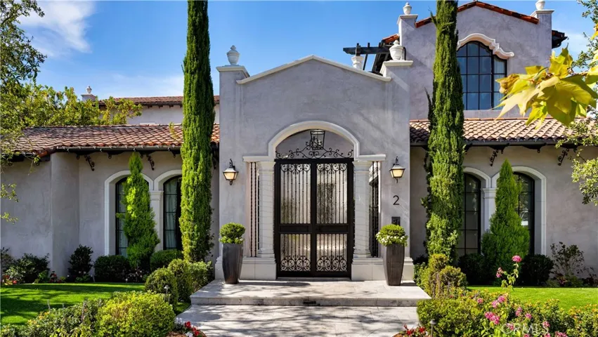 Entering the home through this custom gate is simply a hint of what else is to come at 2 Thomas Rd. The contemporary adobe- style exterior complements the walnut inlays seen in cabinetry, baseboards, ceilings and doors inside.