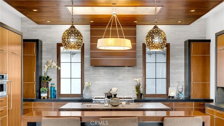State of the art appliances include a Sub Zero double refrigerator and freezer, a Viking 8 burner range, with custom range hood, double oven and microwave . Two appliance garage units flank the back windows.Notice the exact placement of the lighting.