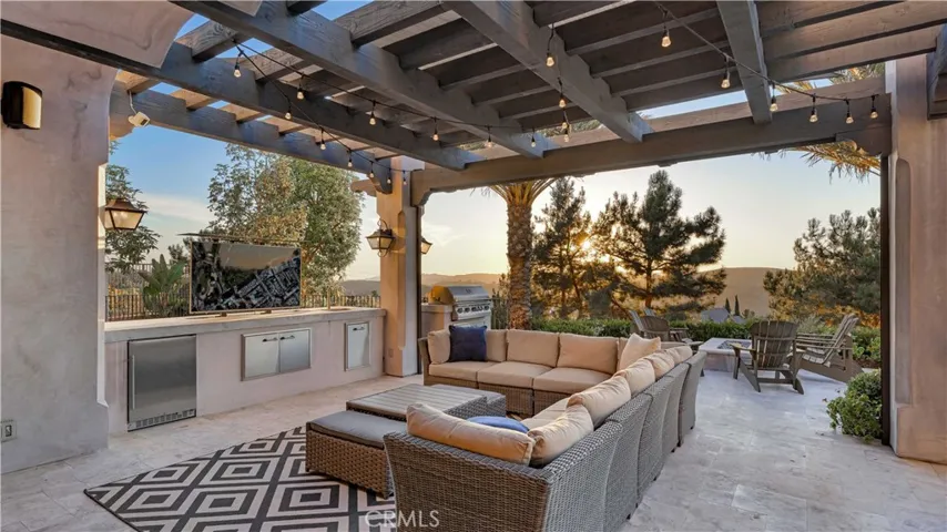 Host unforgettable gatherings with the outdoor kitchen, firepit and bluestone travertine decking. From your comfortable living area, watch favorite shows from a hidden automated TV station.