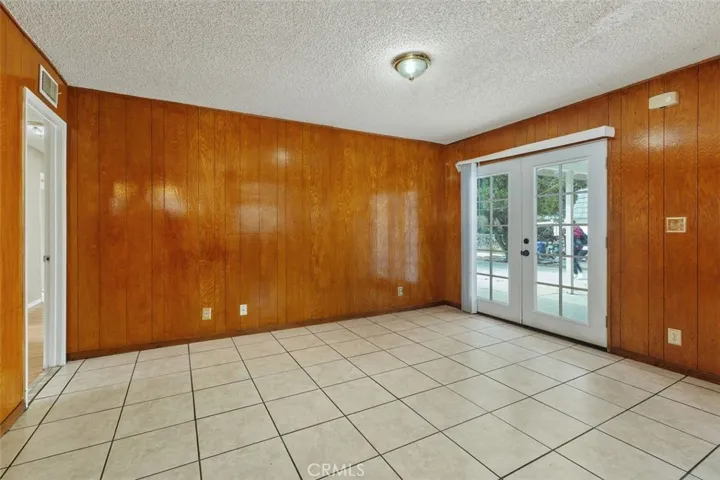 French-styled doors provide a perfect blend of indoor comfort and outdoor beauty, bathing the room in natural light while providing an effortless flow to the patio.