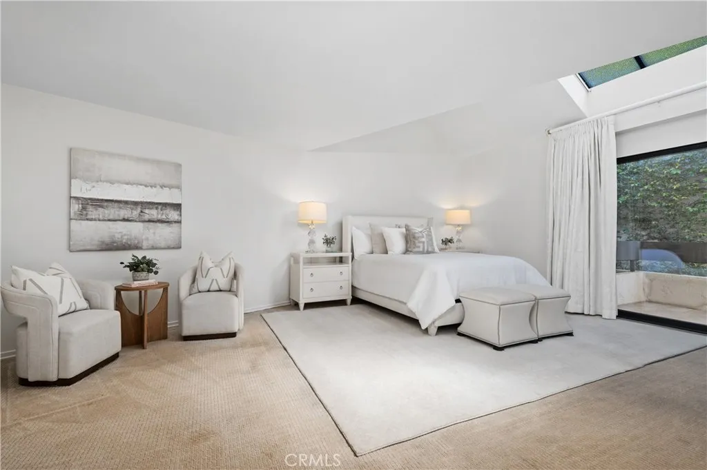 Double door entry into the large primary bedroom.  High ceiling with skylights and sliding doors out to the back balcony.