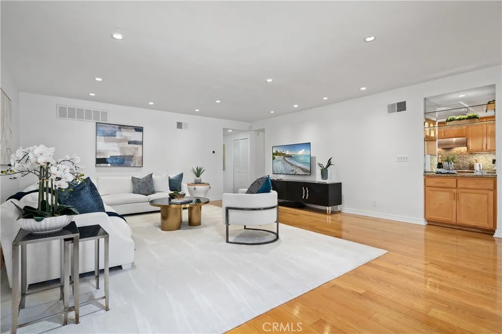 Living spaces and kitchen connected by a built in wet bar with a sink, allowing effortless preparation and serving while remaining engaged with guests.
