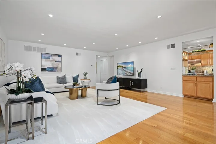 Living spaces and kitchen connected by a built in wet bar with a sink, allowing effortless preparation and serving while remaining engaged with guests.