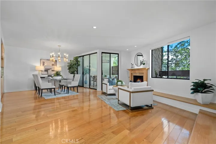 A cozy seating area at the fireplace with a generous hearth flows into the formal dining area and out to the front balcony through corner positioned sliding glass doors.