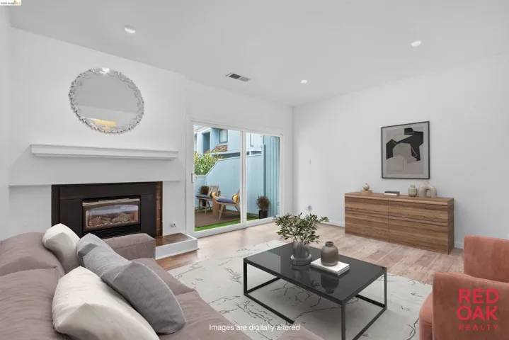Living room with light wood finished floors, a glass covered fireplace, and recessed lighting
