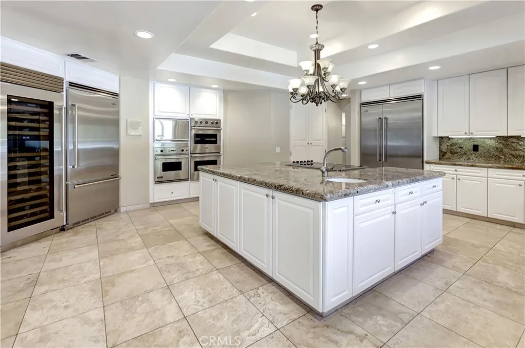 Kitchen: Sub-Zero wine cooler on the far left, 2 refrigerators, 3 ovens