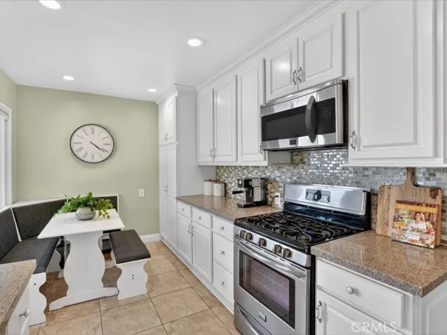 White Cabinets with knobs and pulls. Stainless appliances, granite countertops