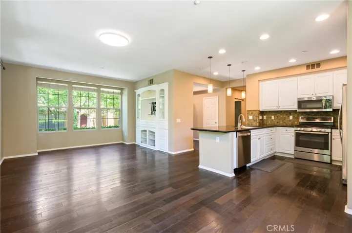 The open kitchen overlooks the gorgeous great room which has been upgraded with a beautiful built-in media cabinet and ENGINEERED WOOD FLOORING.