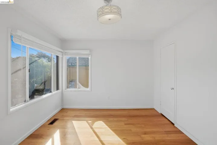 Unfurnished room featuring light wood-type flooring and a textured ceiling