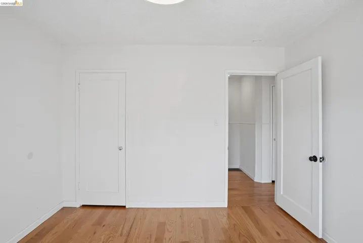 Unfurnished bedroom featuring light wood-type flooring and a textured ceiling