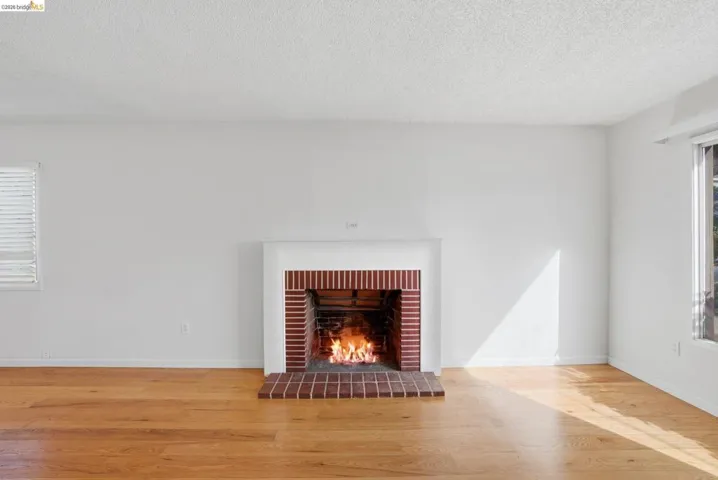 Detailed view of wood finished floors, a tile fireplace, and a textured ceiling