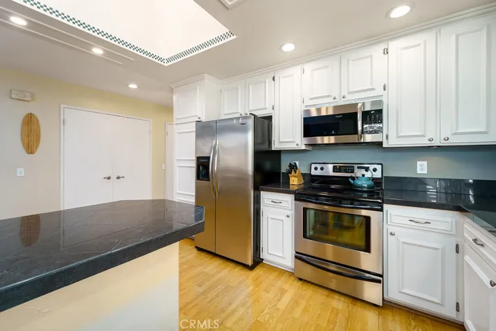 Newer kitchen cabinets with dark granite counter tops.